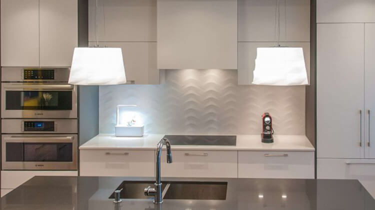 Rénovation de cuisine avec armoires blanches et luminaires suspendus